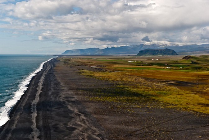 Dlouhá černá pláž táhnoucí se podél oceánu
