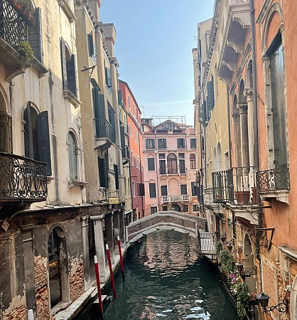 Kanál v Benátkách s kamenným mostem a barevnými domy