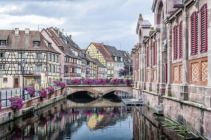 Kanál lemovaný historickými domy s mostem ozdobeným květinami