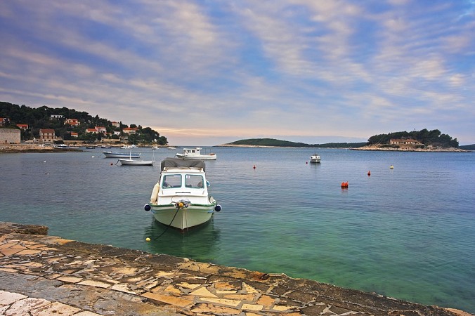 Bílé lodě kotví na klidném moři u pobřeží ostrova Hvar