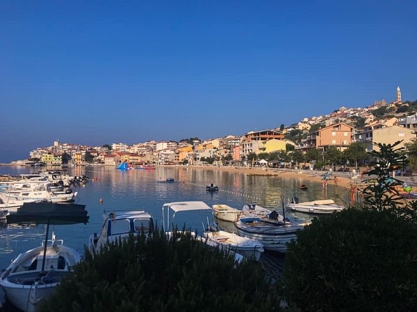 Přístavní městečko s barevnými domy osvětlenými zapadajícím sluncem