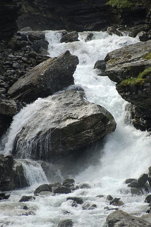 Horský vodopád proudící mezi kameny a skalami