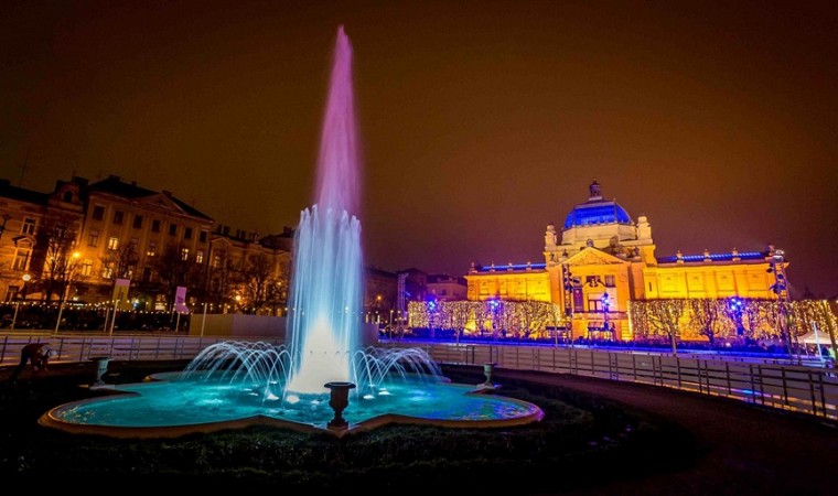 Umělecký pavilon v Záhřebu osvětlený v noci, s barevně nasvícenou fontánou