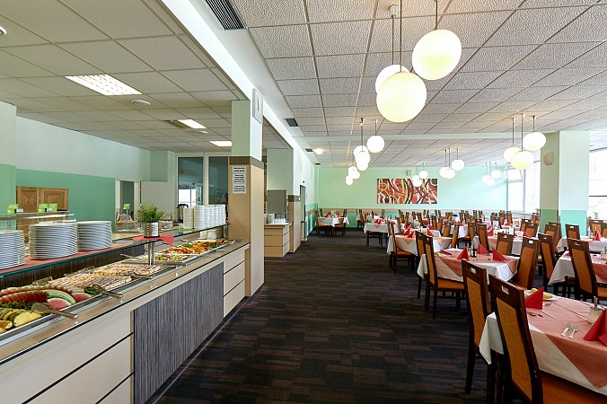 Světlá hotelová jídelna s bufetovým pultem