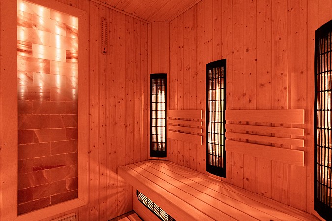 Moderní dřevěná sauna s teplým osvětlením a lavicemi