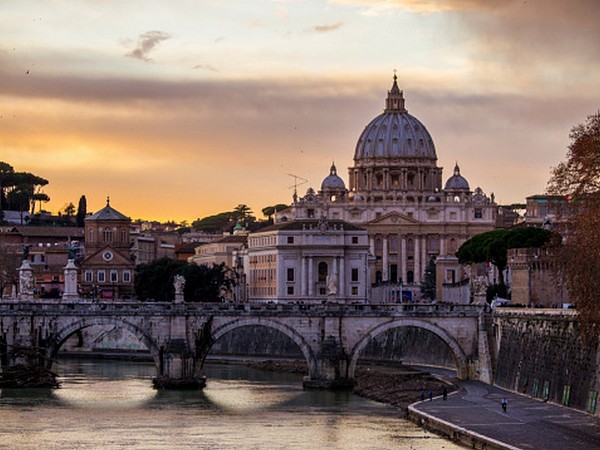 Řím, pohled přes řeku Tevere na Ponte Sant’Angelo a Basilica di San Pietro při západu slunce