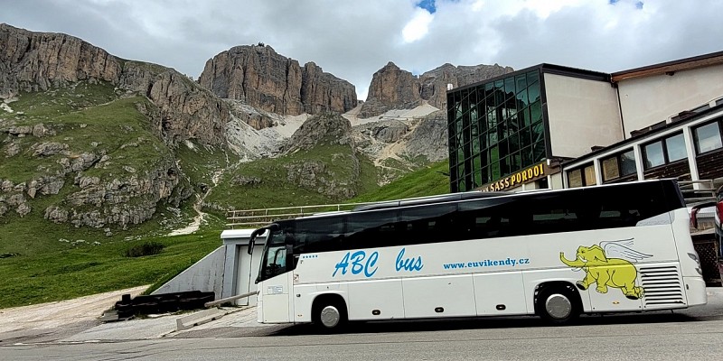 Autobus stojící u moderní budovy s prosklenou částí