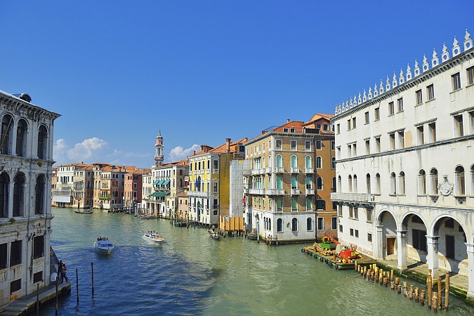 Úzký kanál je lemován vysokými historickými domy s balkony a obloukovými okny