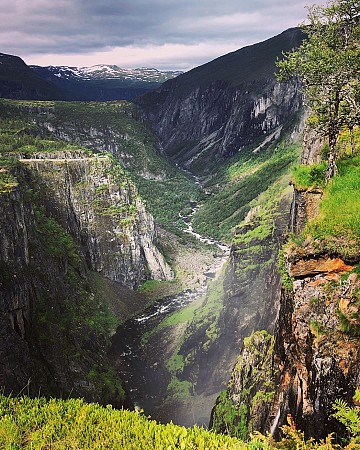 trmé zelené údolí s hlubokou roklí a vysokým vodopádem, který padá po skále dolů