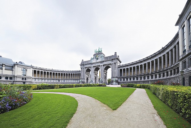 Budova v bruselském Parc du Cinquantenaire s obloukovým průčelím a trávníkem