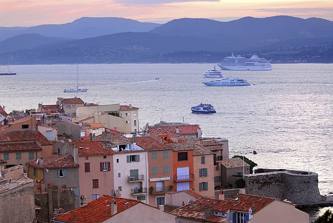 Střechy domů u moře s trajekty