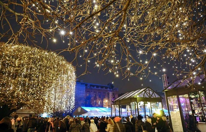 Ulice v Záhřebu s vánoční výzdobou, nad hlavami lidí září tisíce světýlek