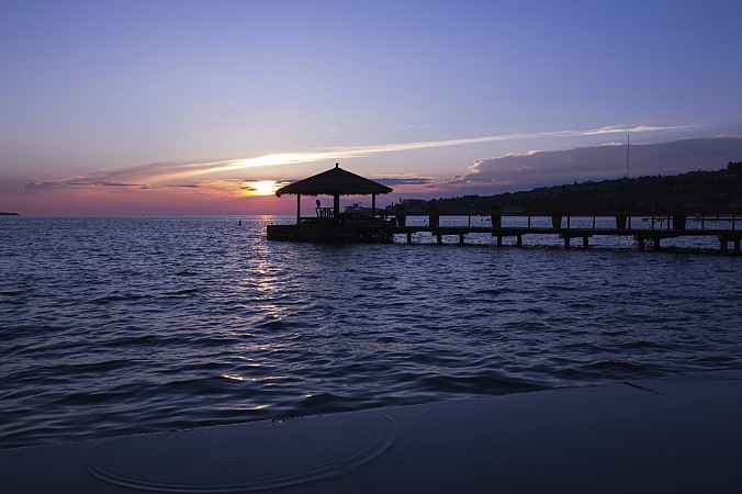 Molo s altánkem na hladině jezera při západu slunce