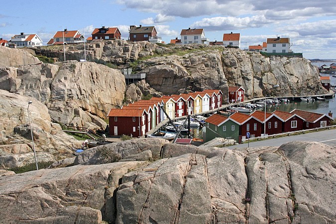 Skalnaté pobřeží ve švédském Smögenu s červenými a bílými domky u vody