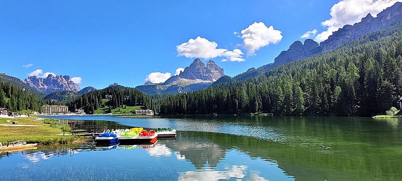 Jezero s čistou zelenomodrou vodou, u břehu je dřevěné molo s několika loďkami