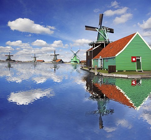Nizozemsko, větrné mlýny a tradiční dřevěné domy v Zaanse Schans u vodní hladiny