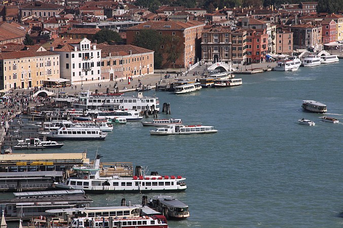 Pobřeží Benátek lemují historické budovy a přístaviště plné lodí a vaporett na vodním kanále