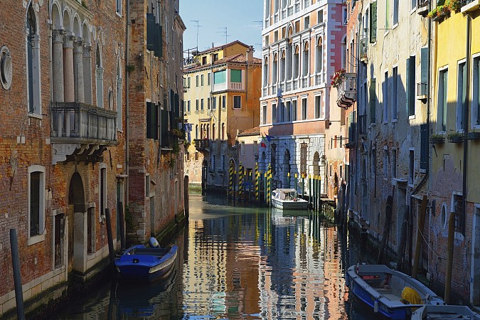 Úzký kanál v Benátkách obklopený barevnými domy
